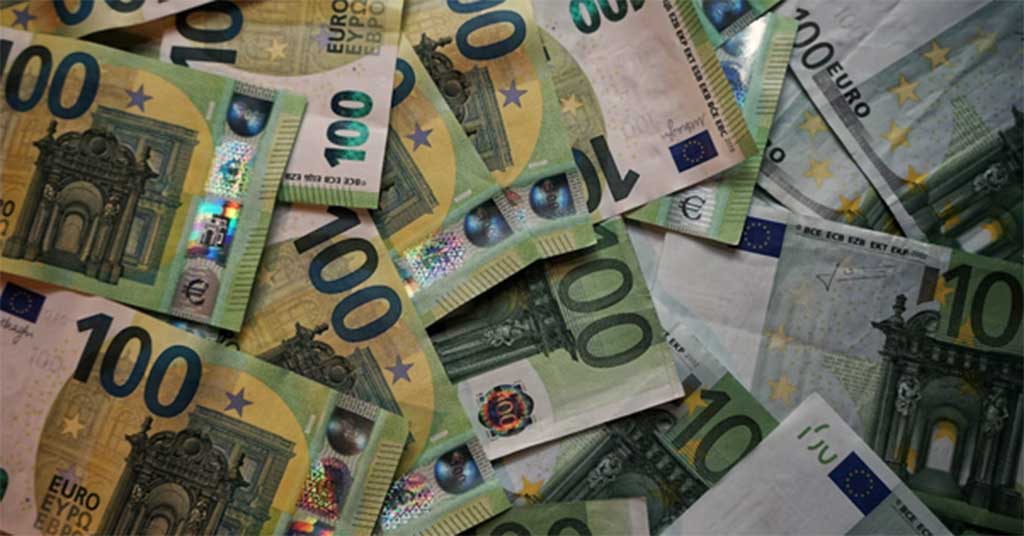 Currency • Troy Media Overlapping 100-euro banknotes scattered in a pile.
