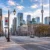 Downtown Toronto street with CN Tower in the distance, Canadian flags, and glass office towers amid autumn trees in fall light.