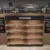 Empty wooden display shelf labeled 'American' in a liquor store, with bottle shelves on either side still stocked.