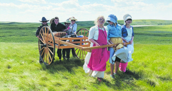 Youth pull handcarts across the prairie in pioneer re-enactment